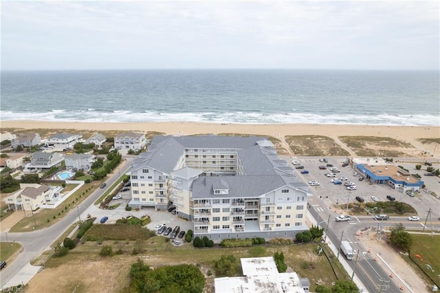 birds eye view of property with a water view and a beach view