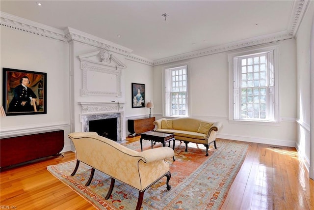 living room featuring ornamental molding, hardwood / wood-style floors, and a premium fireplace