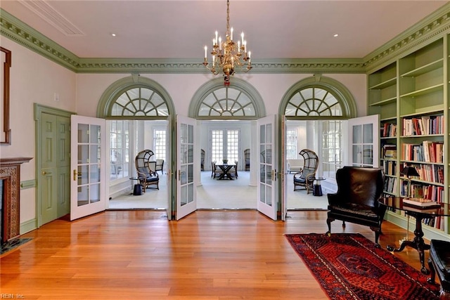 entryway featuring light wood-type flooring, crown molding, and french doors