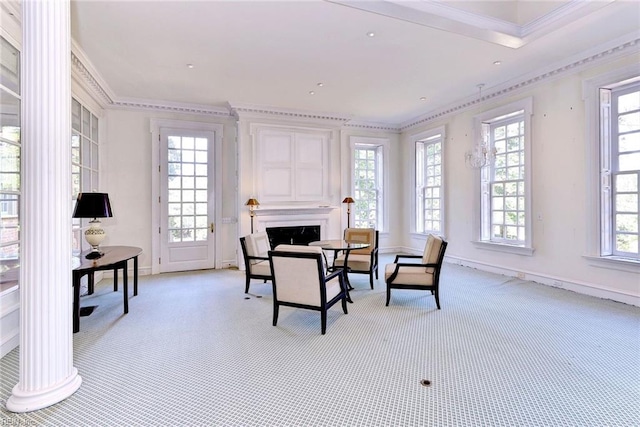 living area with a high end fireplace, a healthy amount of sunlight, and crown molding