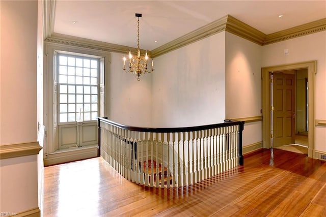 interior space with a chandelier, hardwood / wood-style floors, and crown molding