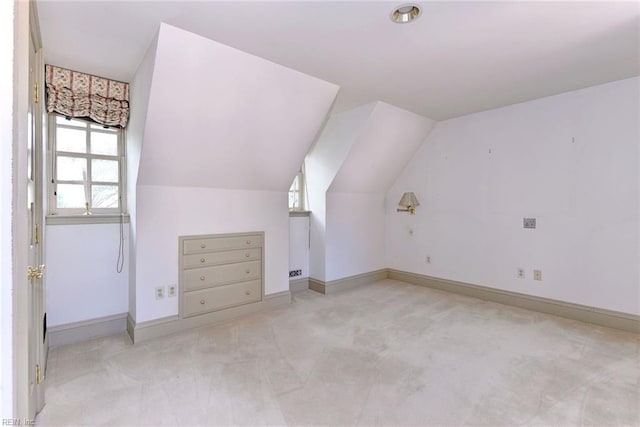 bonus room with lofted ceiling and light colored carpet