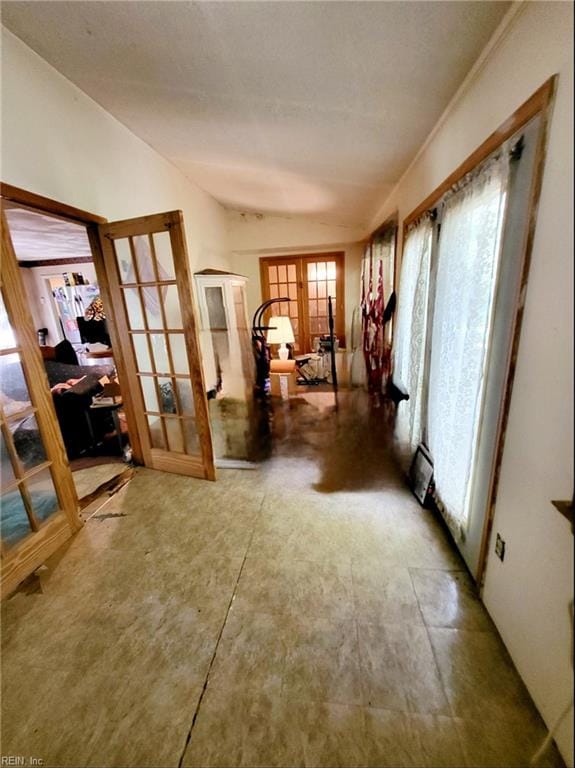 hallway featuring concrete flooring and french doors