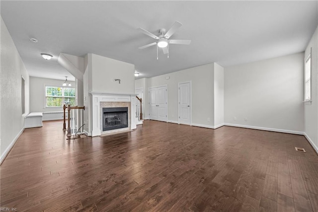 unfurnished living room with ceiling fan, a fireplace, and dark hardwood / wood-style flooring