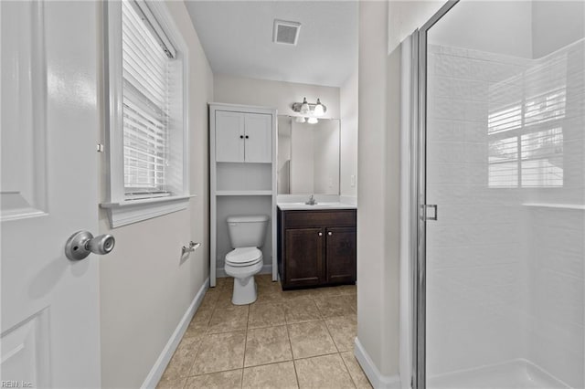 bathroom with a healthy amount of sunlight, vanity, toilet, and a shower with shower door