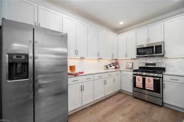 kitchen with light wood-type flooring, white cabinetry, and appliances with stainless steel finishes