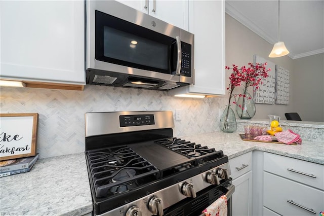 kitchen with white cabinets, appliances with stainless steel finishes, decorative light fixtures, ornamental molding, and light stone countertops