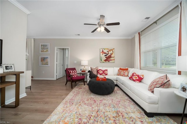 living room featuring ornamental molding, light wood-type flooring, and ceiling fan