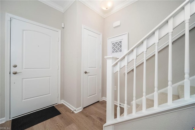 entryway with wood-type flooring and ornamental molding