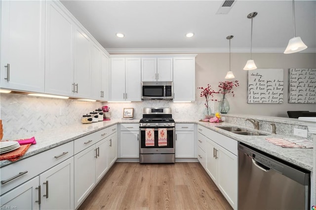 kitchen with light wood-type flooring, sink, white cabinetry, appliances with stainless steel finishes, and decorative light fixtures