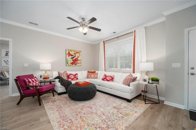 living room featuring light wood-type flooring, ceiling fan, and crown molding