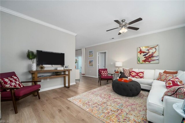 living room featuring light wood-type flooring, ceiling fan, and crown molding