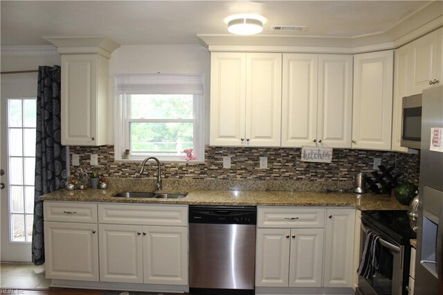 kitchen featuring a wealth of natural light, white cabinets, appliances with stainless steel finishes, and sink