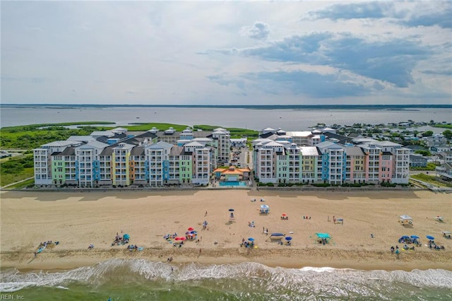 birds eye view of property featuring a water view and a beach view