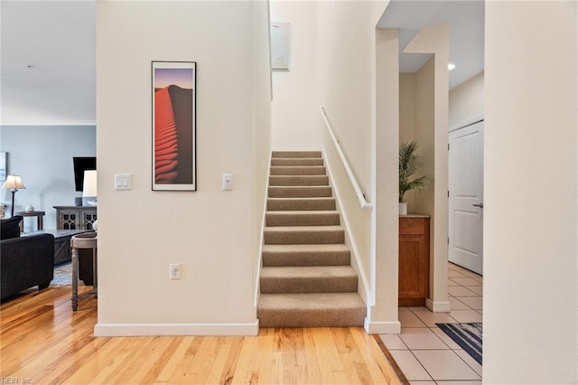 stairway featuring wood-type flooring and crown molding