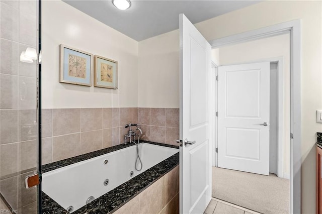 bathroom featuring tile patterned floors and a relaxing tiled tub