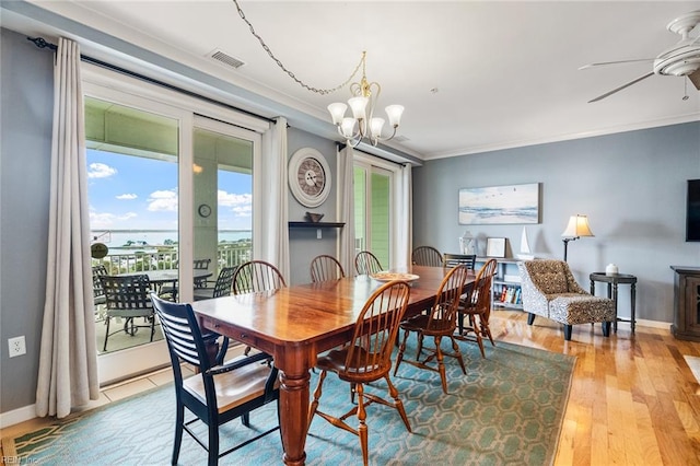 dining space with ceiling fan with notable chandelier, light hardwood / wood-style floors, and ornamental molding