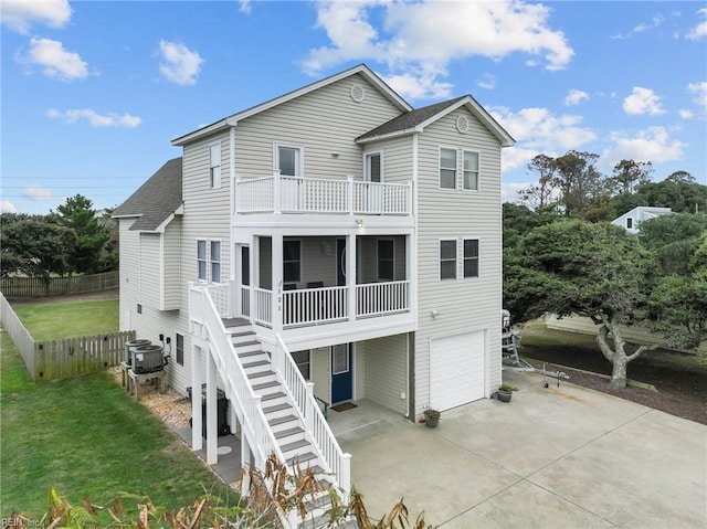 rear view of house with a balcony, cooling unit, and a garage