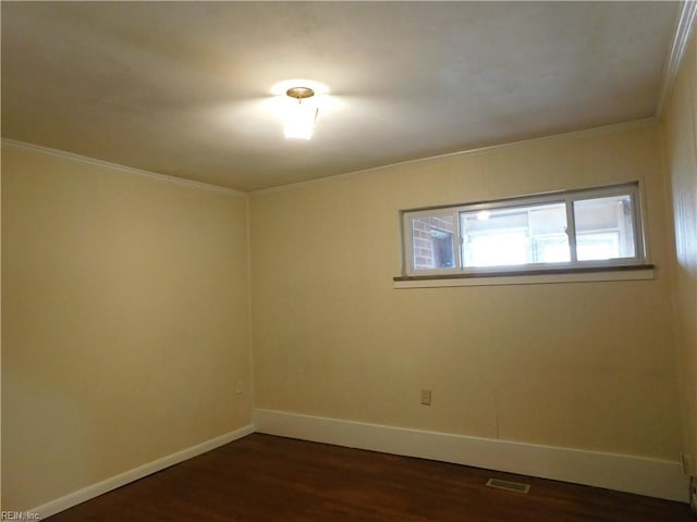 empty room with dark hardwood / wood-style floors and crown molding