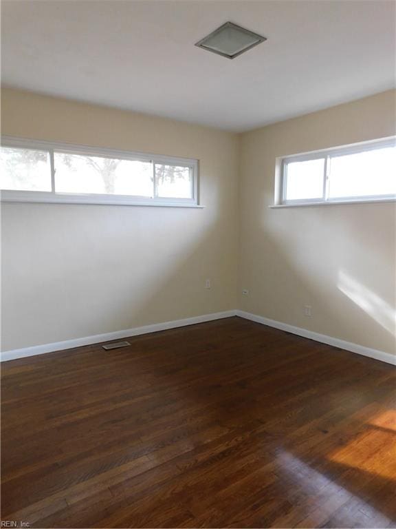 unfurnished room with plenty of natural light and dark hardwood / wood-style flooring