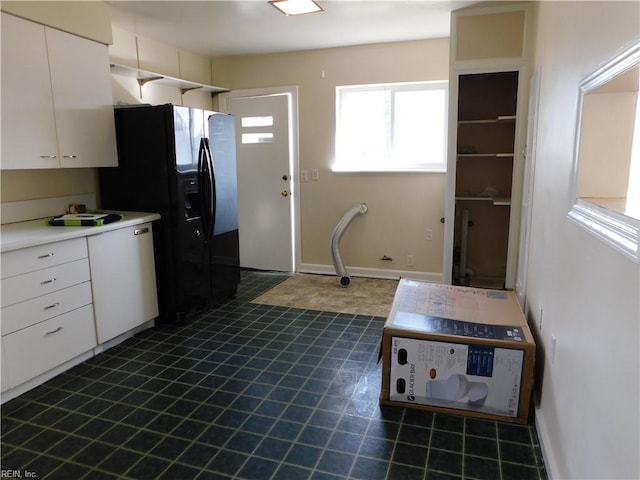 kitchen with black fridge and white cabinetry