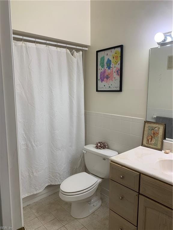 bathroom with a shower with curtain, vanity, toilet, and tile patterned floors