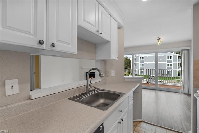 kitchen featuring stove, sink, plenty of natural light, and white cabinets