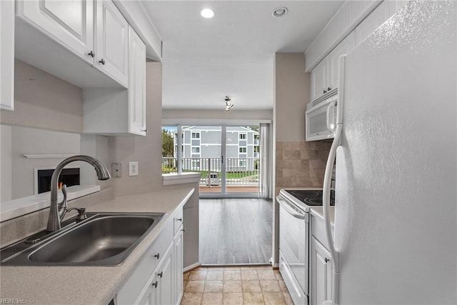 kitchen featuring tasteful backsplash, white appliances, sink, and white cabinets