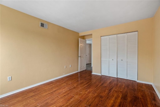 unfurnished bedroom featuring wood-type flooring and a closet