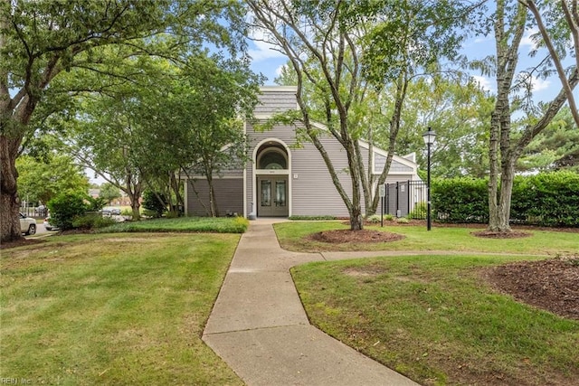 view of front of home with french doors and a front lawn