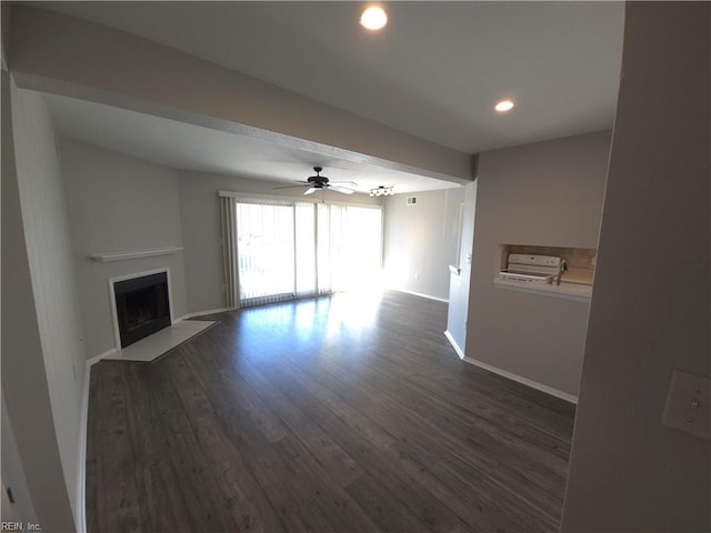 unfurnished living room with ceiling fan and dark hardwood / wood-style flooring