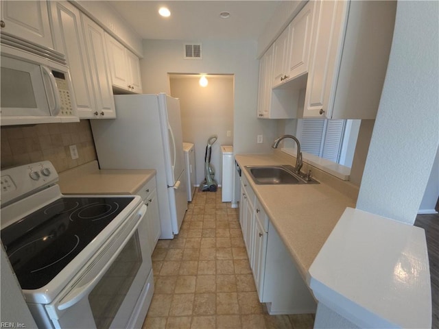 kitchen featuring washer / dryer, sink, backsplash, white cabinets, and white appliances