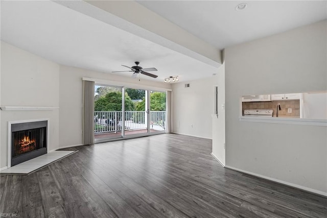 unfurnished living room featuring dark wood-type flooring and ceiling fan