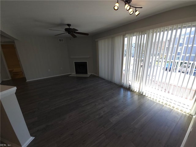 unfurnished living room featuring ceiling fan and dark hardwood / wood-style flooring