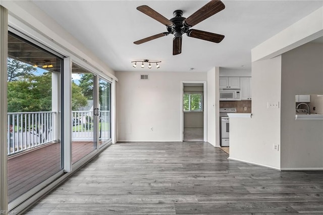 unfurnished living room featuring sink, ceiling fan, and light hardwood / wood-style flooring