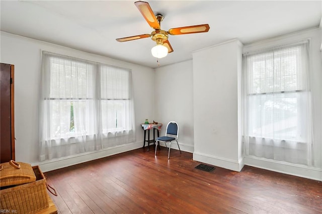 sitting room featuring ceiling fan, crown molding, and dark hardwood / wood-style flooring