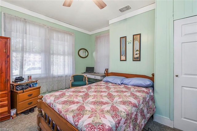 carpeted bedroom featuring ceiling fan and crown molding