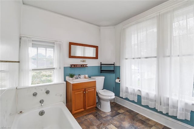 bathroom with vanity, toilet, and a bath