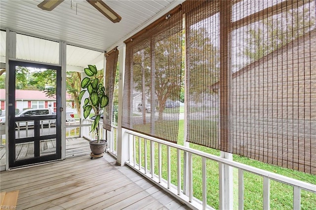 unfurnished sunroom with ceiling fan