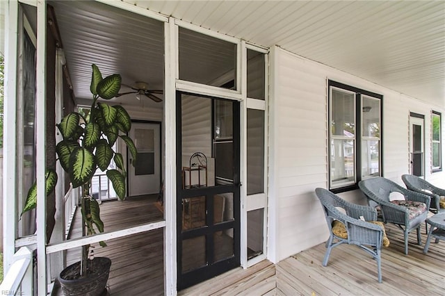 wooden terrace with ceiling fan and covered porch