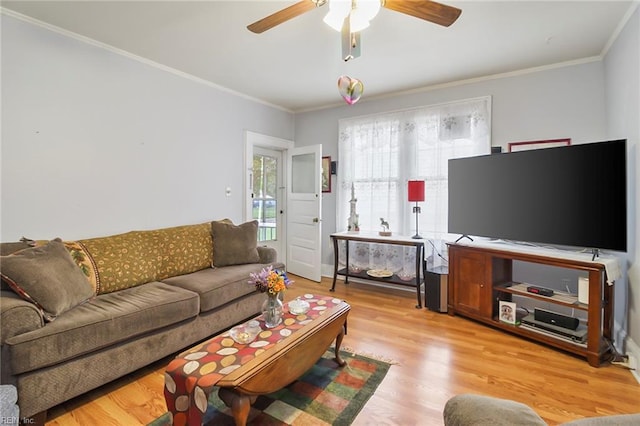 living room with ornamental molding, light wood-type flooring, and ceiling fan