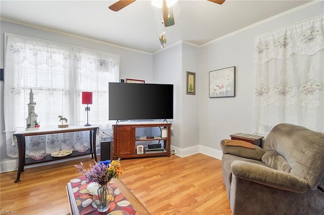 living room with crown molding, light hardwood / wood-style floors, and ceiling fan