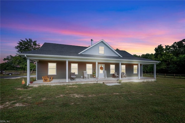 farmhouse featuring a lawn and covered porch