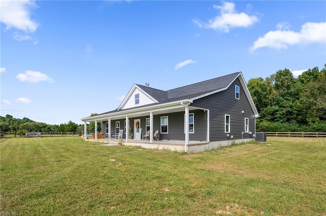 rear view of property featuring a lawn and central AC unit