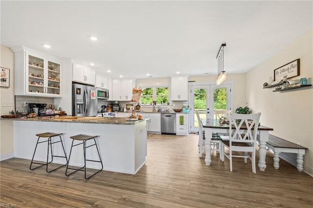 15338 Everets Rd, Windsor, VA 23487 - kitchen featuring stainless steel appliances, a peninsula, white cabinetry, glass insert cabinets, and wood finished floors