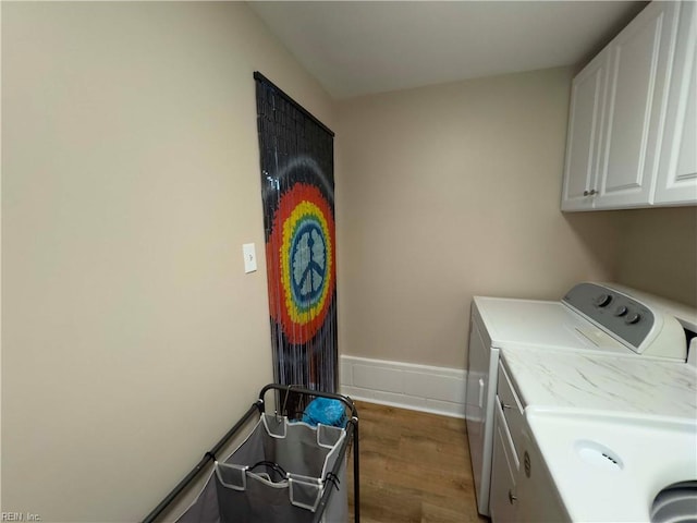 washroom with cabinets, independent washer and dryer, and dark hardwood / wood-style flooring