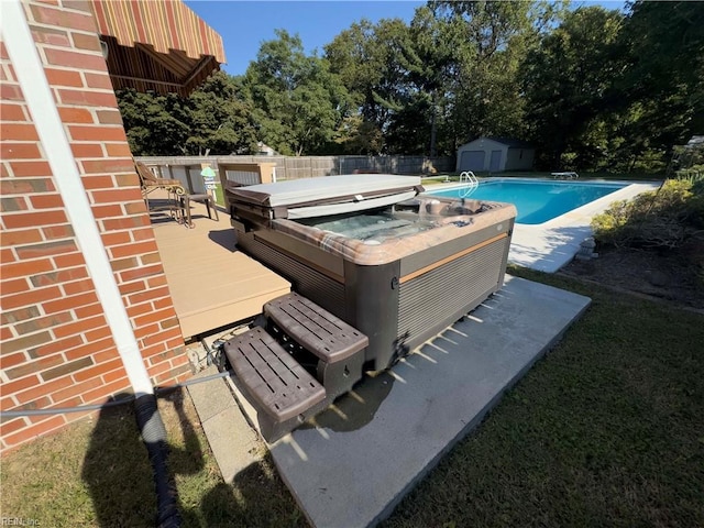 view of swimming pool featuring a deck and a hot tub