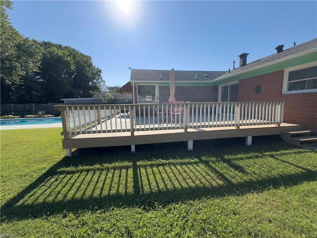 back of house featuring a pool side deck and a yard