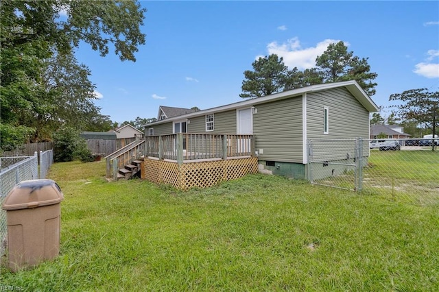 back of house featuring a lawn and a deck