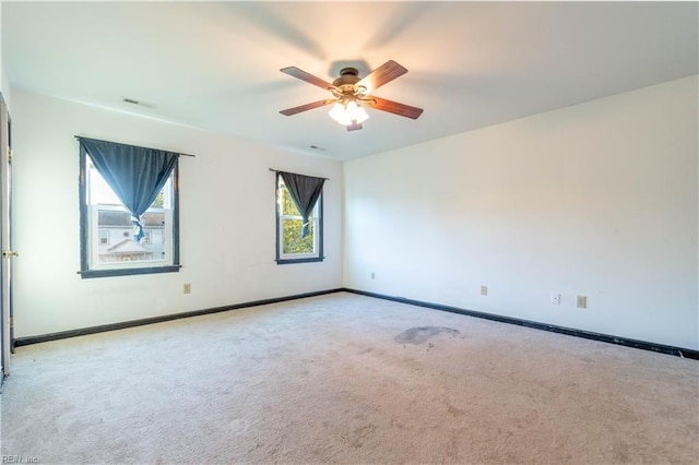 carpeted spare room featuring ceiling fan